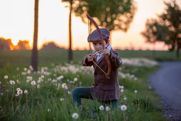 Retrato de criança brincando com arco e flechas, tiro com arco atira um — Fotografia de Stock