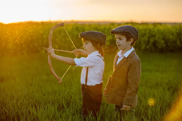 Retrato de crianças brincando com arco e flechas, tiros de tiro com arco — Fotografia de Stock