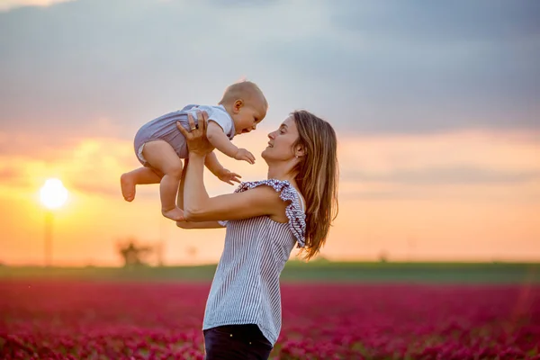 Young mother, embracing with tenderness and care her toddler bab — Stock Photo, Image