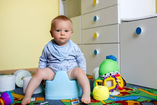 장난감과 화장실의 많은 챔버 냄비에 앉아 미소 아기 — 스톡 사진