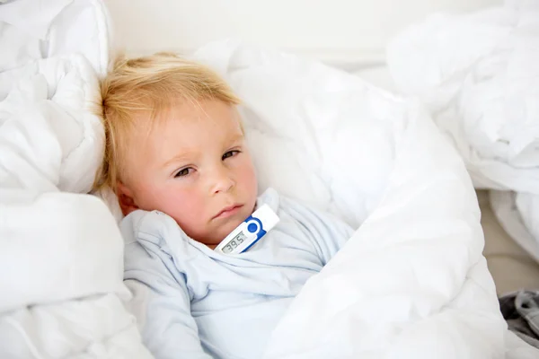 Tired toddler boy with high fever, lying in bed — Stock Photo, Image