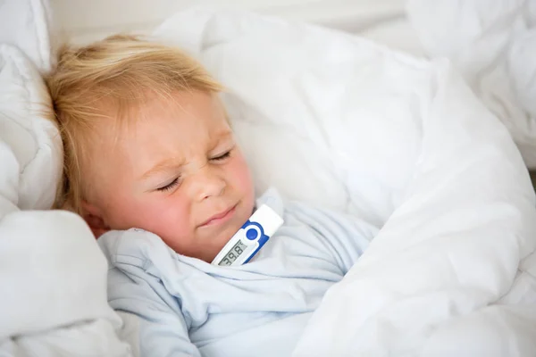 Vermoeide peuter jongen met hoge koorts, liggend in bed — Stockfoto