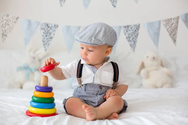 Sød lille barn, baby dreng, leger med farverigt legetøj i solrig - Stock-foto