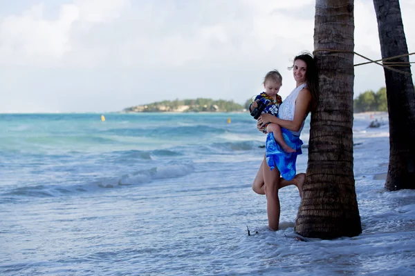 Mamma e bambino ragazzo, felicemente abbracciati sulla riva dell'oceano, relaxin — Foto Stock