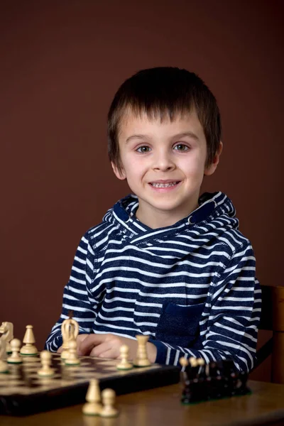 Niño, jugando al ajedrez. Niño inteligente, aislado, jugando al ajedrez —  Fotos de Stock