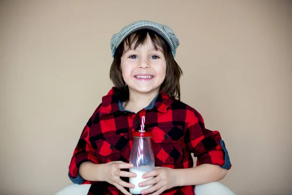 Menino pré-escolar pequeno na moda bonito, bebendo leite de b — Fotografia de Stock