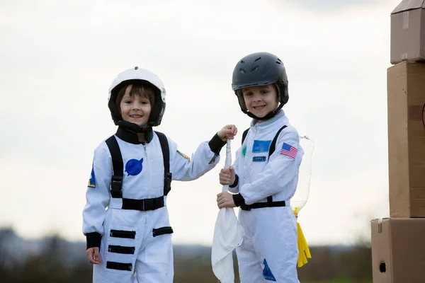 Zwei entzückende Kinder, die im Park bei Sonnenuntergang spielen, angezogen wie ein — Stockfoto