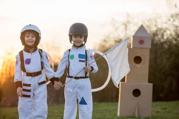 Zwei entzückende Kinder, die im Park bei Sonnenuntergang spielen, angezogen wie ein — Stockfoto