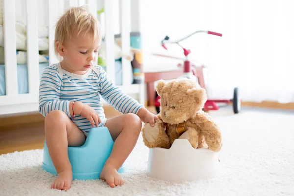 Carino bambino ragazzo, vasino di formazione, giocare con il suo orsacchiotto — Foto Stock