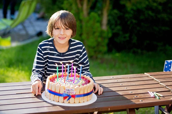 Doce menino pré-adolescente, comemorando seu birhtday com bolo colorido o — Fotografia de Stock