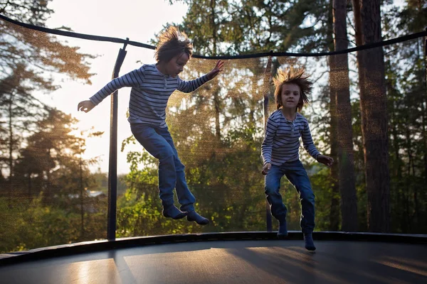 Zoete Preteen jongen springen op trampoline maken van salto's in th — Stockfoto