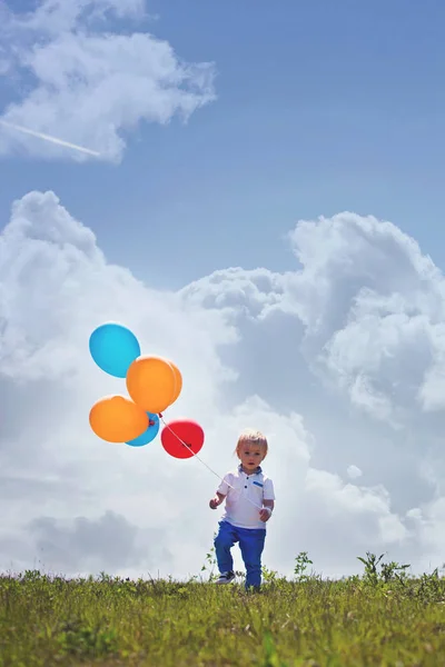 Little boy, toddler, child playing with colorful balloons in the — Stock Photo, Image