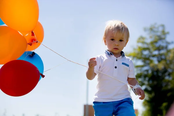 Bambino, bambino, bambino che gioca con palloncini colorati nel — Foto Stock