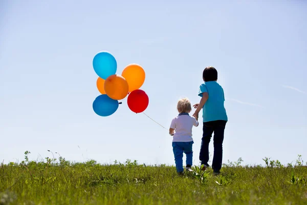 Little boy, toddler, child playing with colorful balloons in the — Stock Photo, Image