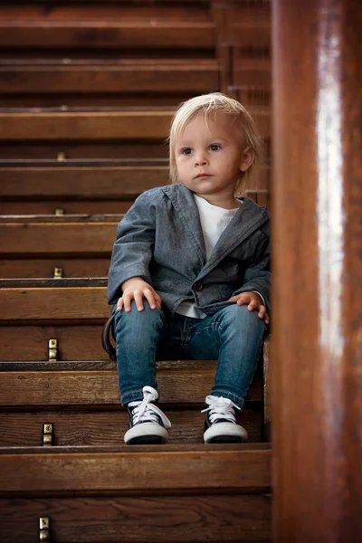 Triest kind, zittend op een trap in een groot huis, concept voor Bu — Stockfoto