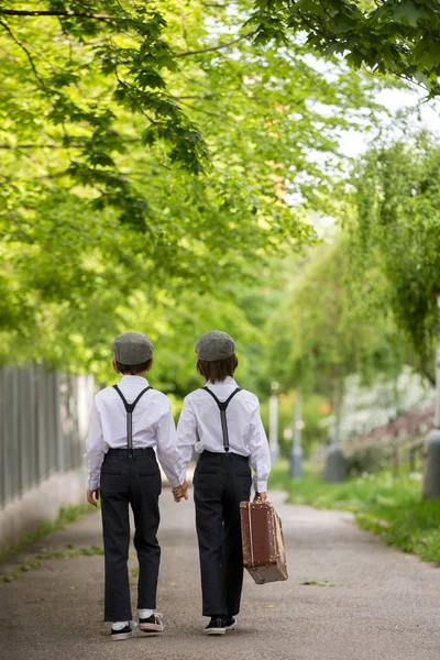 Dolci bambini in abiti vintage, con valigia in mano, che corrono dentro — Foto Stock