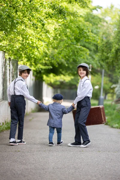 Süße Kinder in Vintage-Klamotten, Koffer haltend, einlaufend — Stockfoto