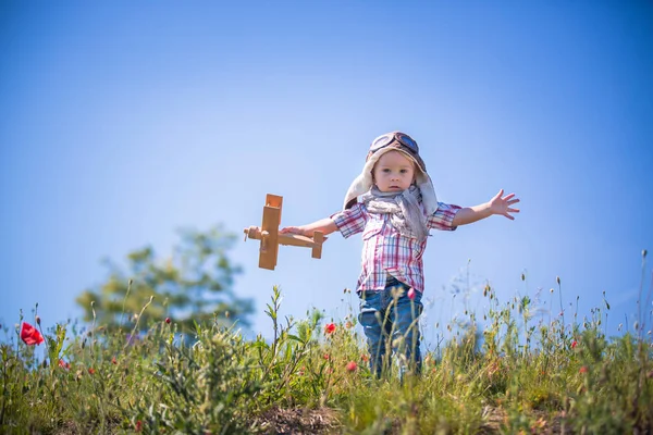 Menino de criança bonita bebê, criança brincando com avião em papoula — Fotografia de Stock