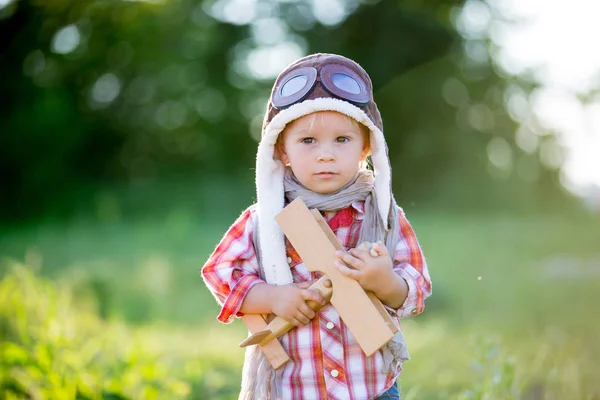 Süßes Kleinkind Baby Junge, Kind spielt mit Flugzeug in Mohn fie — Stockfoto