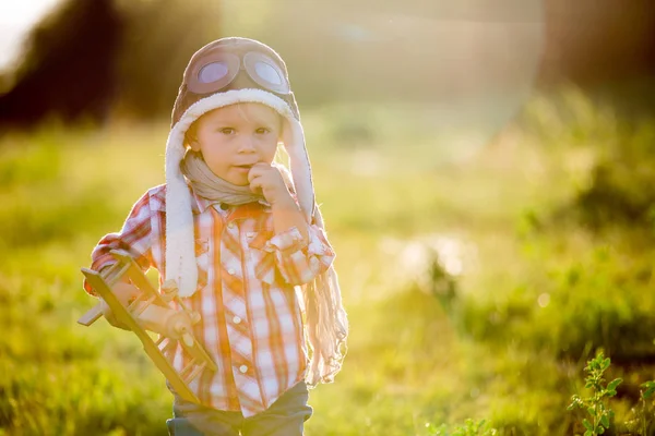 Dolce bambino bambino ragazzo, bambino che gioca con l'aereo in papavero fie — Foto Stock