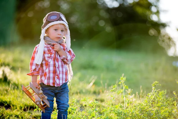 Dulce niño pequeño bebé, niño jugando con avión en amapola fie —  Fotos de Stock