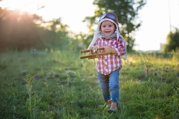 Dolce bambino bambino ragazzo, bambino che gioca con l'aereo in papavero fie — Foto Stock