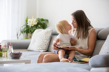 Büyüleyici anne, onu sevimli yürümeye başlayan bebek erkek bebek ile bulmaca yapma