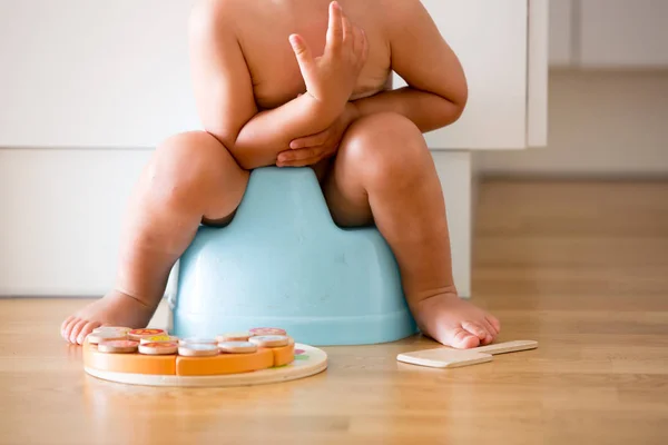 Little småbarn pojke, sitter på potta, leker med trä leksak — Stockfoto
