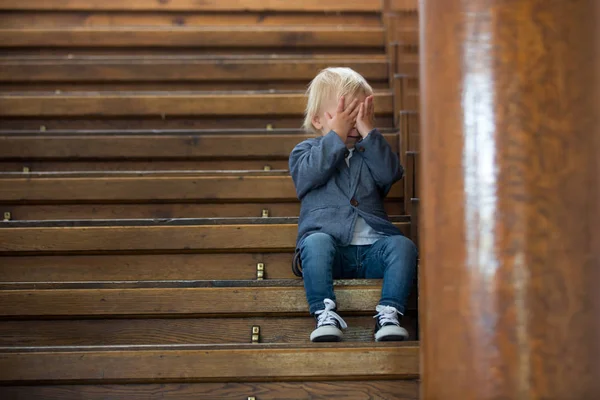 Niño triste, sentado en una escalera en una casa grande, concepto para bu —  Fotos de Stock