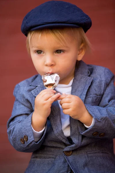 Lindo niño, niño en paños vintage, comer helado de piruleta, si —  Fotos de Stock