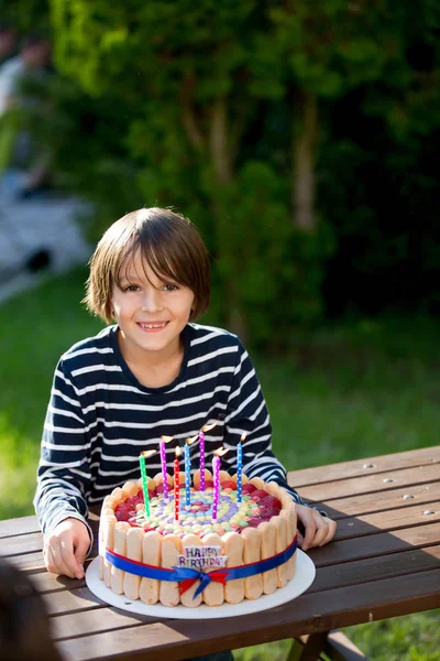 Doce menino pré-adolescente, comemorando seu birhtday com bolo colorido o — Fotografia de Stock