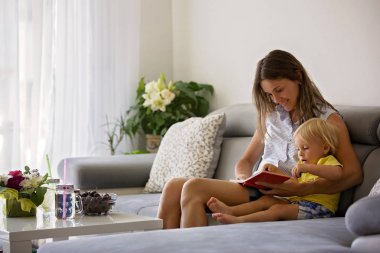Onu sevimli Toddler ba bir kitapta görüntüler gösteren büyüleyici Anne,