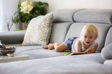 Tatlı Toddler çocuk, bir kanepede oturan, kiraz ve Looki yeme