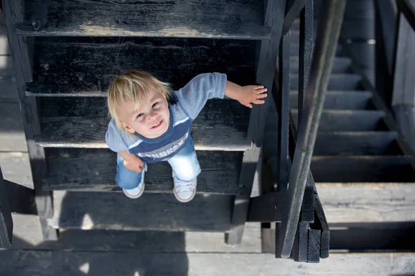 Dziecko, chłopiec maluch, siedzący na drewnianych schodach — Zdjęcie stockowe