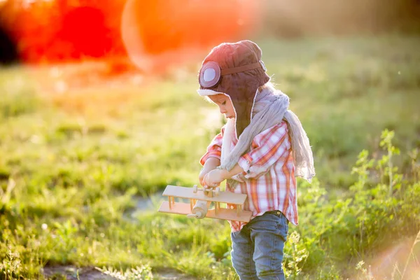 Sweet toddler baby boy, child playing with airplane in poppy fie — Stock Photo, Image