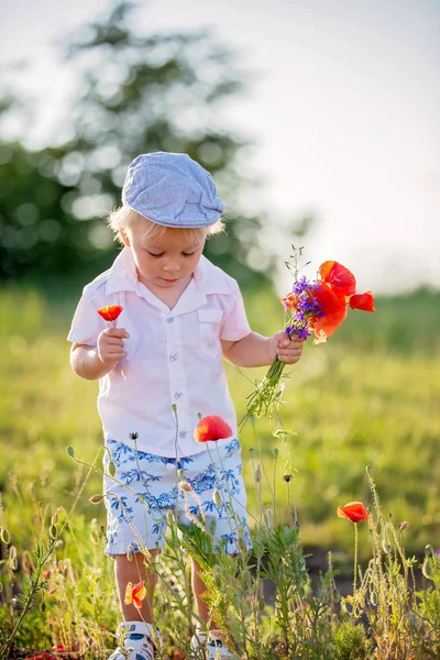 Glücklich schönes Kleinkind, das einen Strauß wilder Blumen in der Hand hält — Stockfoto