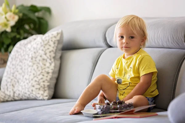 甘い幼児の少年、ソファに座って、チェリーとルキを食べる — ストック写真