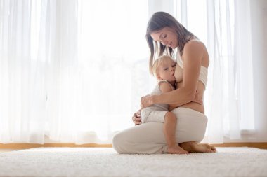 Genç emzirme toddler bebek oğlu evde anne. 