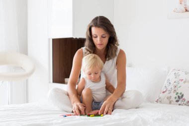 Anne manyetik ahşap ile yatak odasında onu yürümeye başlayan çocuk ile oynar