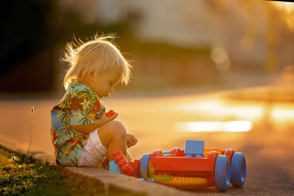 Hermoso niño pequeño, jugando con juguetes de plástico, bloques, coches —  Fotos de Stock