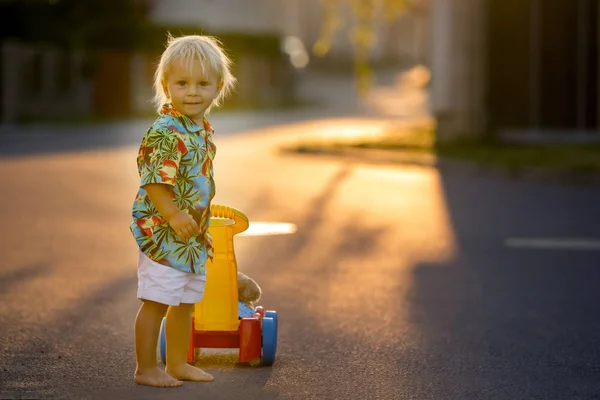 Schönes Kleinkind, das mit Plastikspielzeug, Bauklötzen, Autos spielt — Stockfoto