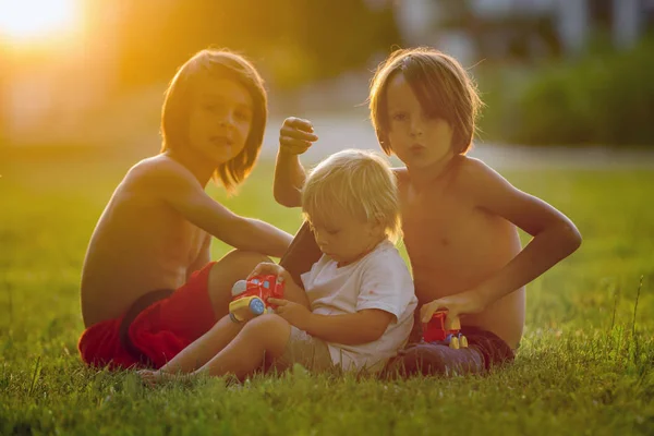 Gyönyörű totyogó gyermek és testvérek, játék műanyag játékokkal, — Stock Fotó
