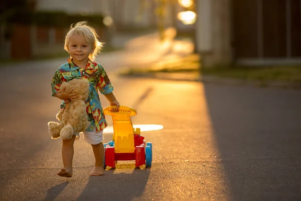 Criança bonita, brincando com brinquedos de plástico, blocos, carros — Fotografia de Stock