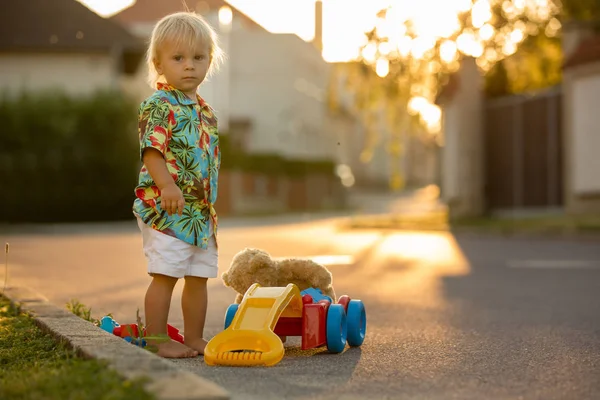 Mooie peuter kind, spelen met plastic speelgoed, blokken, auto's — Stockfoto