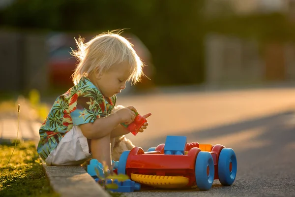 Красива дитина, грається з пластиковими іграшками, блоками, машинами — стокове фото