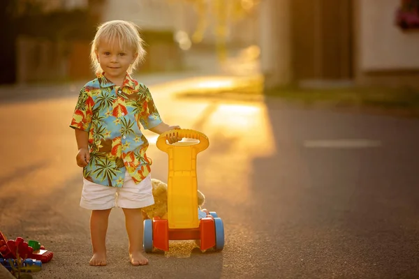 Hermoso niño pequeño, jugando con juguetes de plástico, bloques, coches — Foto de Stock