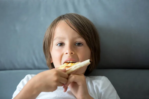 Aranyos kis kaukázusi gyerek eszik pizzát. Éhes gyermek vesz egy bi — Stock Fotó