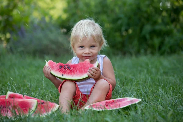 Sevimli yürümeye başlayan çocuk, bebek çocuk, bahçede olgun karpuz yeme — Stok fotoğraf