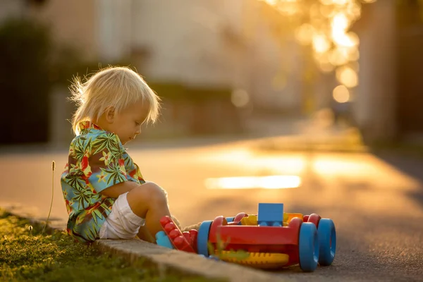 Criança bonita, brincando com brinquedos de plástico, blocos, carros — Fotografia de Stock