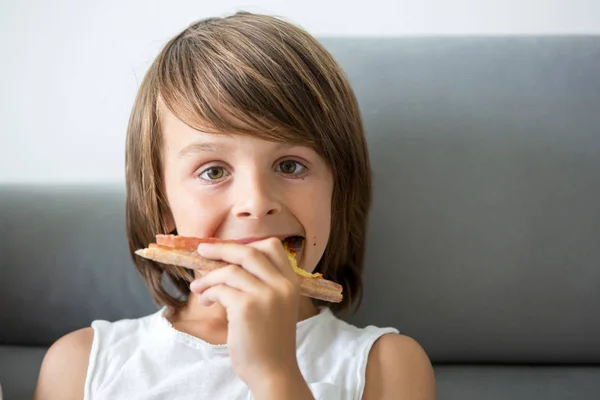 Schattige kleine Kaukasische Kid eten pizza. Hongerig kind het nemen van een bi — Stockfoto